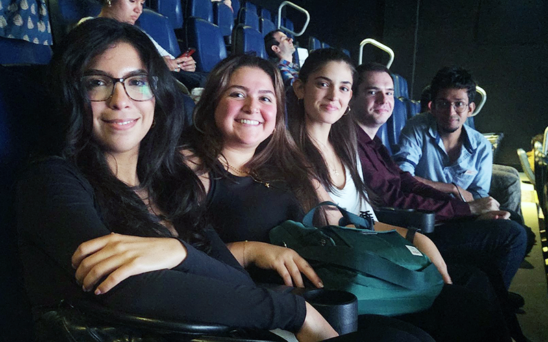 Five FIMS students sitting in a darkened movie theatre at TIFF 2023.