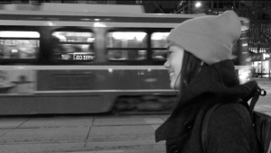 01: Girl smiling while waiting for streetcar. Medium Close Up & Eye Level Shot (Bordwell and Thompson, 189).