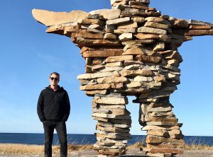Colm Cobb Howes standing beside a rock structure