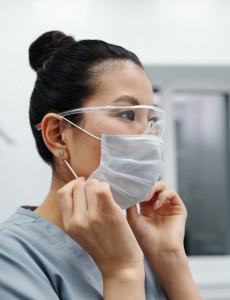 Female nurse wearing a face mask and goggles