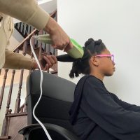 02: My mom using a hair-steamer to detangle the hair before washing it. Low Angle (Bordwell and Thompson, 189) and Size Difference (Block, 27)